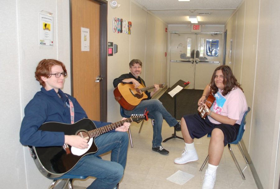 Cranfill teaching guitar to a couple of his students.
