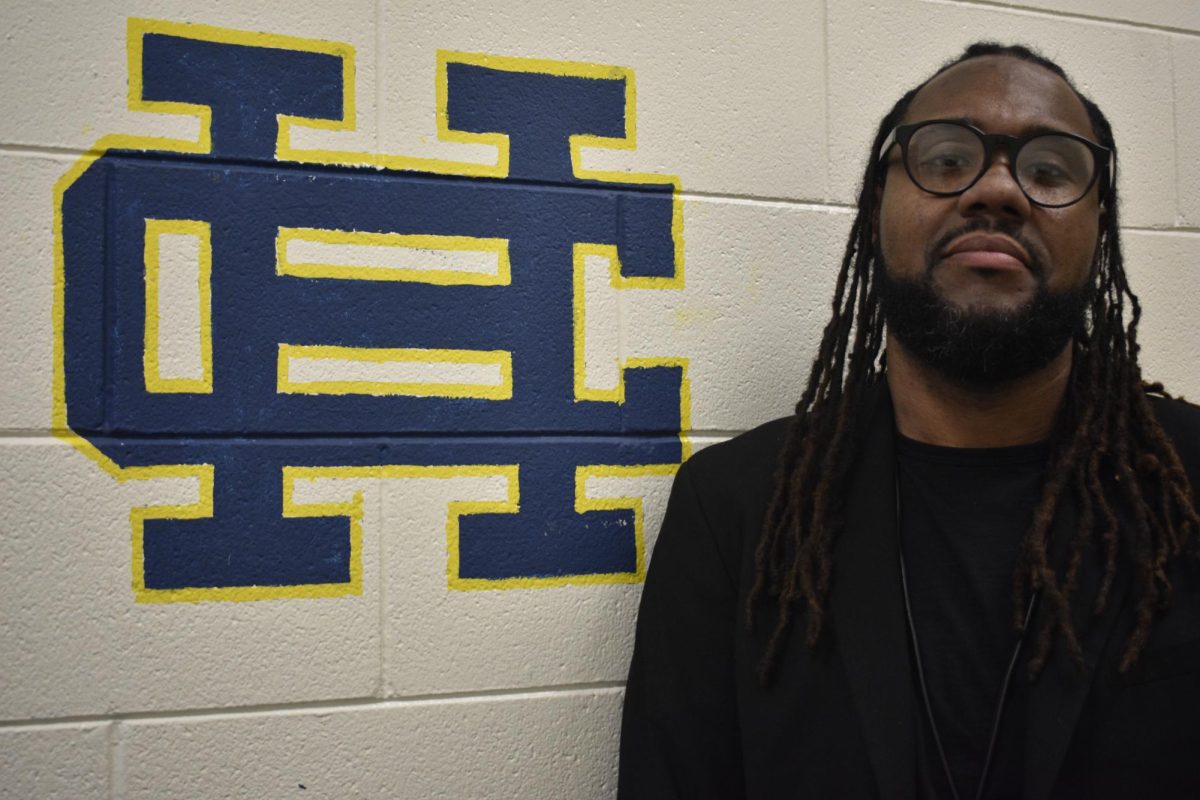 New head principal Dr. Corye Franklin pictured next to the HC emblem. 