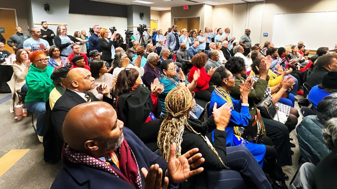 Board meeting attendees watching Dr. Liggins' contract renewal.