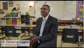 Dr. Liggins sitting in a classroom while being interviewed.